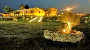 Um edifício com uma entrada bem iluminada e um caminho de pedra que leva até ele.