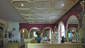 A spacious room with a large central island, arched doorways, and a decorative ceiling. - Hotel Cavalieri (Passignano sul Trasimeno)