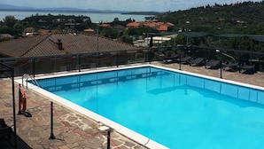 A swimming pool with a view of a lake and distant mountains. - Hotel Cavalieri (Passignano sul Trasimeno)
