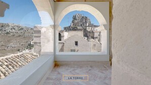 Habitación con vista a un edificio histórico a través de un ventanal arqueado.