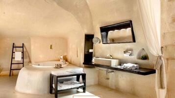 Un baño moderno con una bañera independiente, un tocador con espejo y un perchero para toallas.