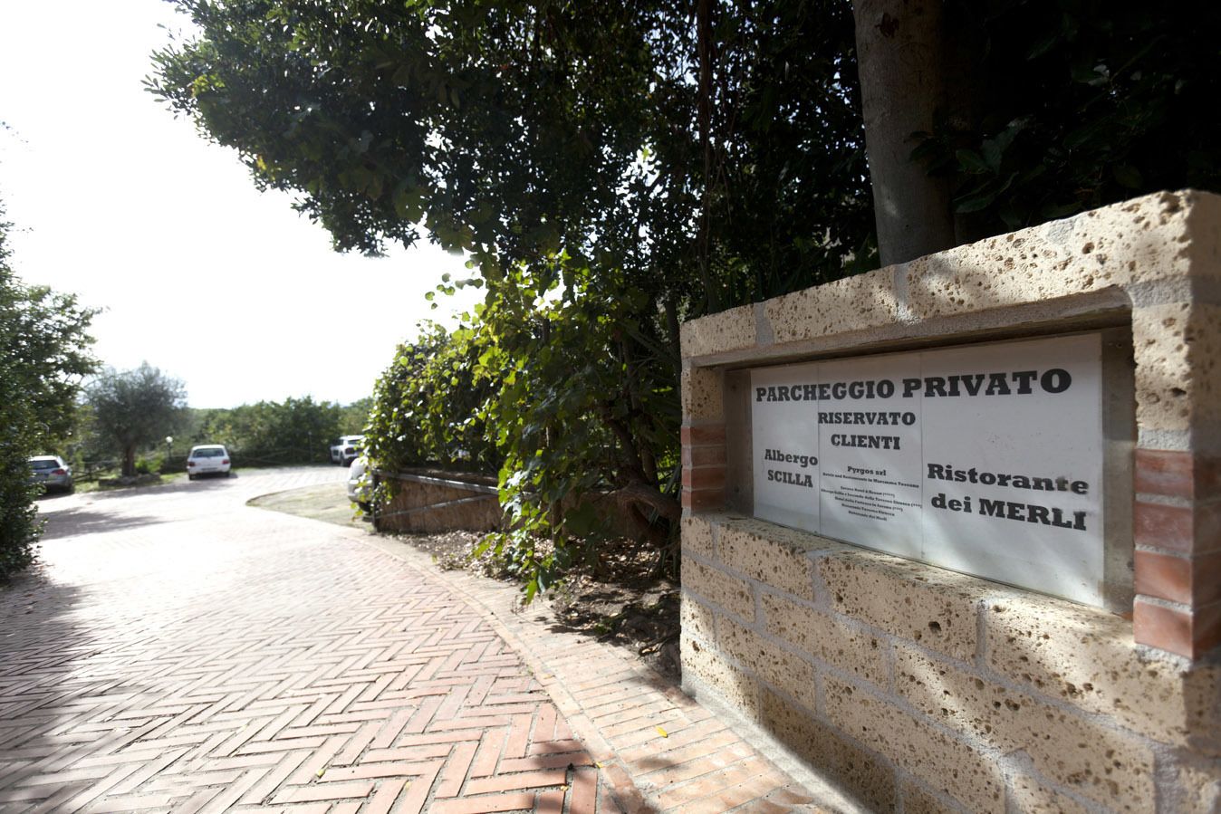 A private parking area with a sign indicating it is reserved for clients of a restaurant named 'Ristorante dei Merli'.