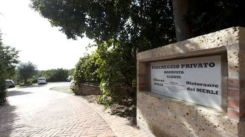 A private parking area with a sign indicating it is reserved for clients of a restaurant named 'Ristorante dei Merli'.