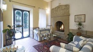 Ein Wohnzimmer mit Kamin, gestreiften Sofas und einem Schachbrett.