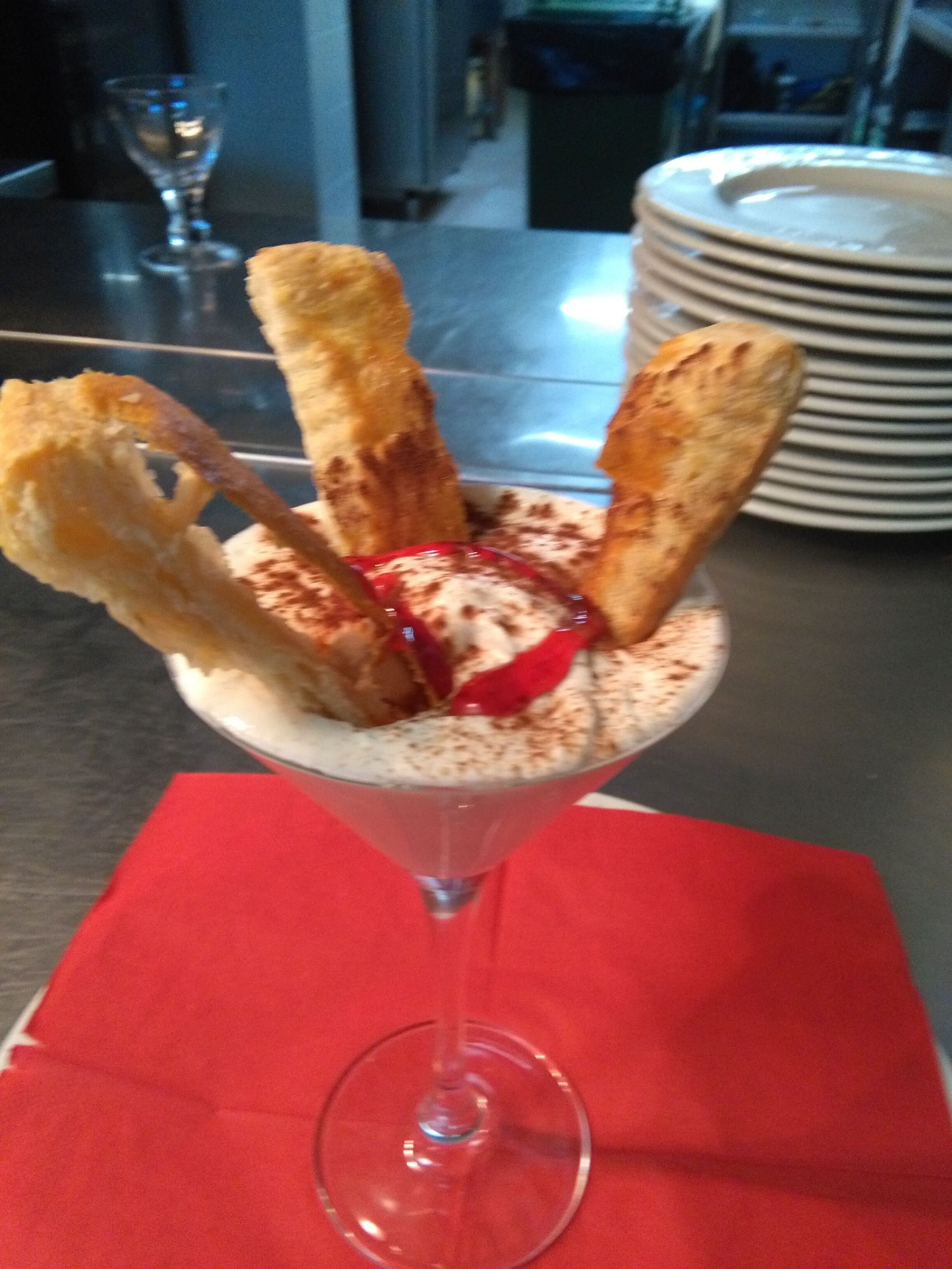 A dessert in a glass with a red napkin underneath.