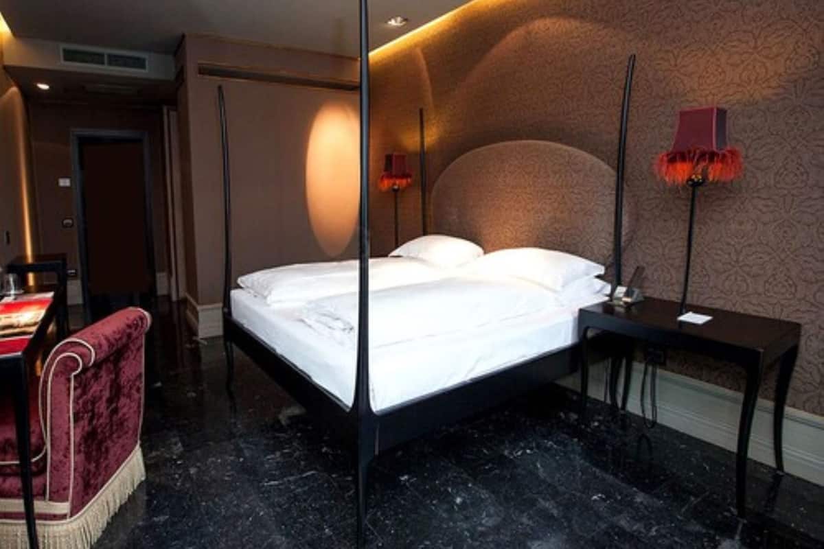 Ein modernes Hotelzimmer mit einem großen Bett, einem Schreibtisch und einem Sessel.