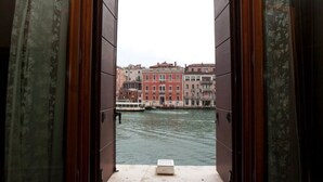 A room with an open window overlooking a canal with buildings. - Palazzo Barbarigo Sul Canal Grande (Venice)