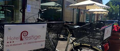 Un vélo muni d’un panier et d’une pancarte indiquant l’emplacement de l’hôtel Prestige.