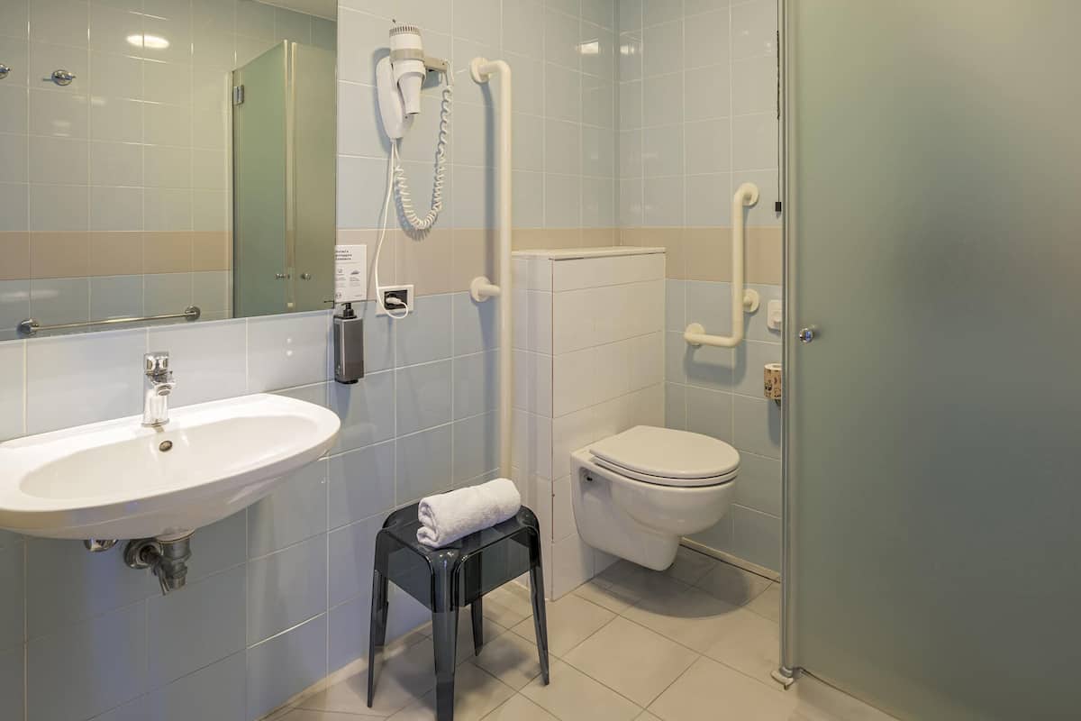 A modern bathroom with a sink, toilet, and glass shower enclosure.
