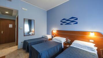 Habitación de hotel con dos camas individuales, un cabecero de madera, un espejo y un logotipo en la pared.