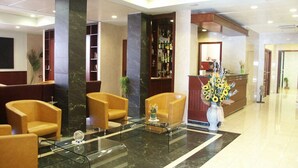 Una hall con reception, area salotto e bar.