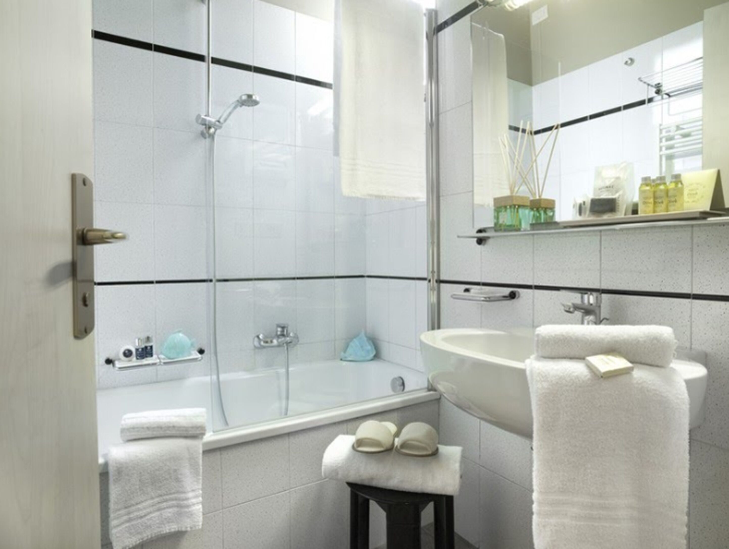 A modern bathroom with a glass-enclosed shower, a freestanding bathtub, and a vanity with a mirror.