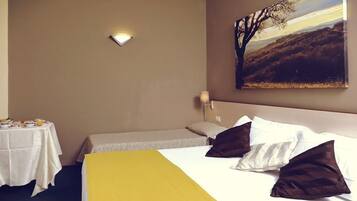 Ein Hotelzimmer mit Bett, Nachttisch mit Lampe, einem Bild an der Wand und einer gelben Bettdecke.