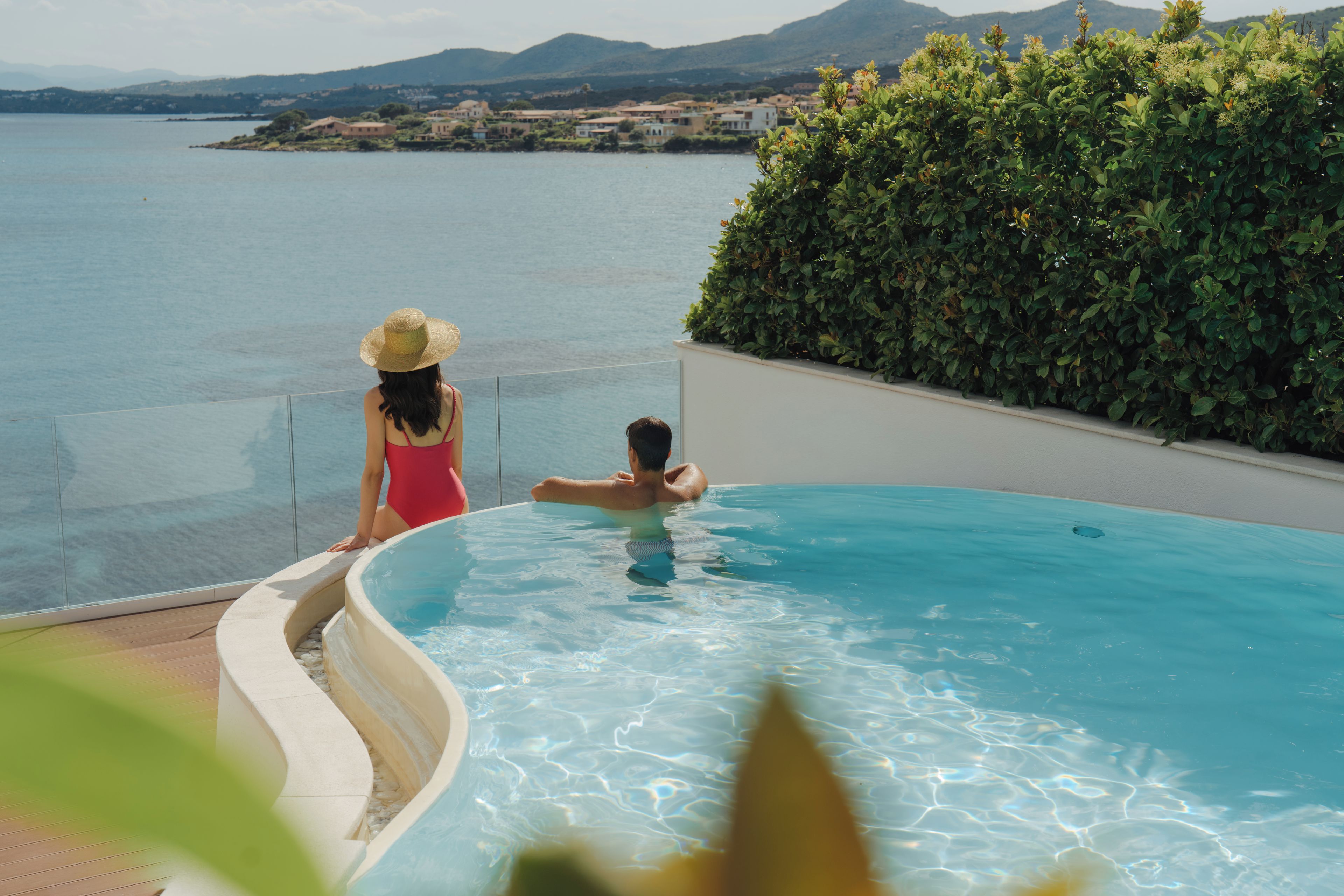 Una piscina con vista al mar y una costa lejana.