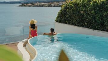 Una piscina con vista al mar y una costa lejana.