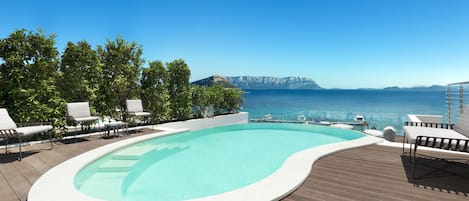 Une piscine à bord incurvé, entourée de chaises longues et d’une terrasse en bois.