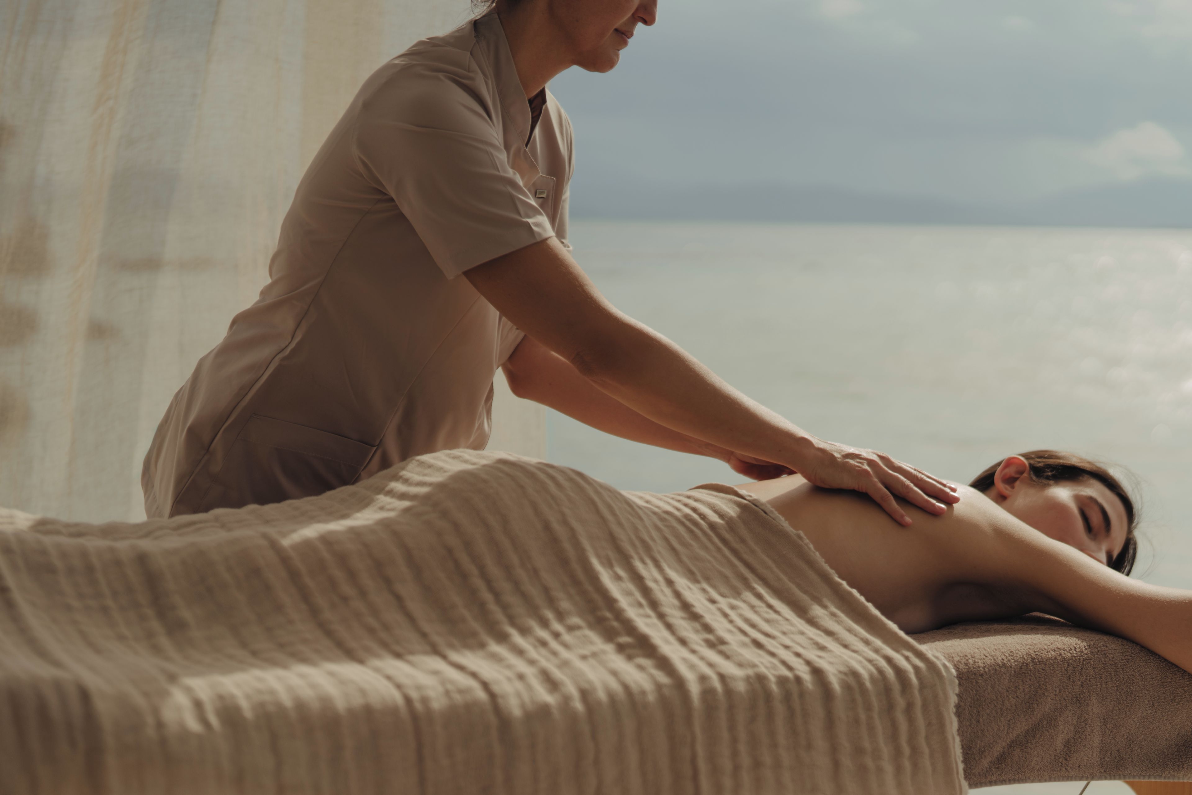 Une séance de massage dans une salle avec vue sur la mer.