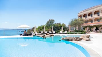 Een buitenzwembad, parasols bij het zwembad en ligstoelen