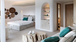Un dormitorio moderno con cama, sofá, mesa de centro y estantería empotrada.