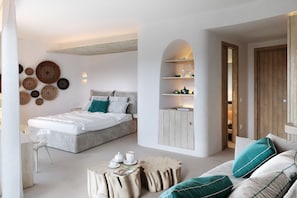Une chambre moderne comprenant un lit, un canapé, une table basse et une bibliothèque intégrée.