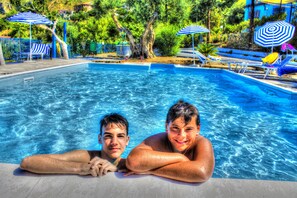 A swimming pool with lounge chairs and umbrellas. - Hotel Piccolo Mondo (Acquappesa)