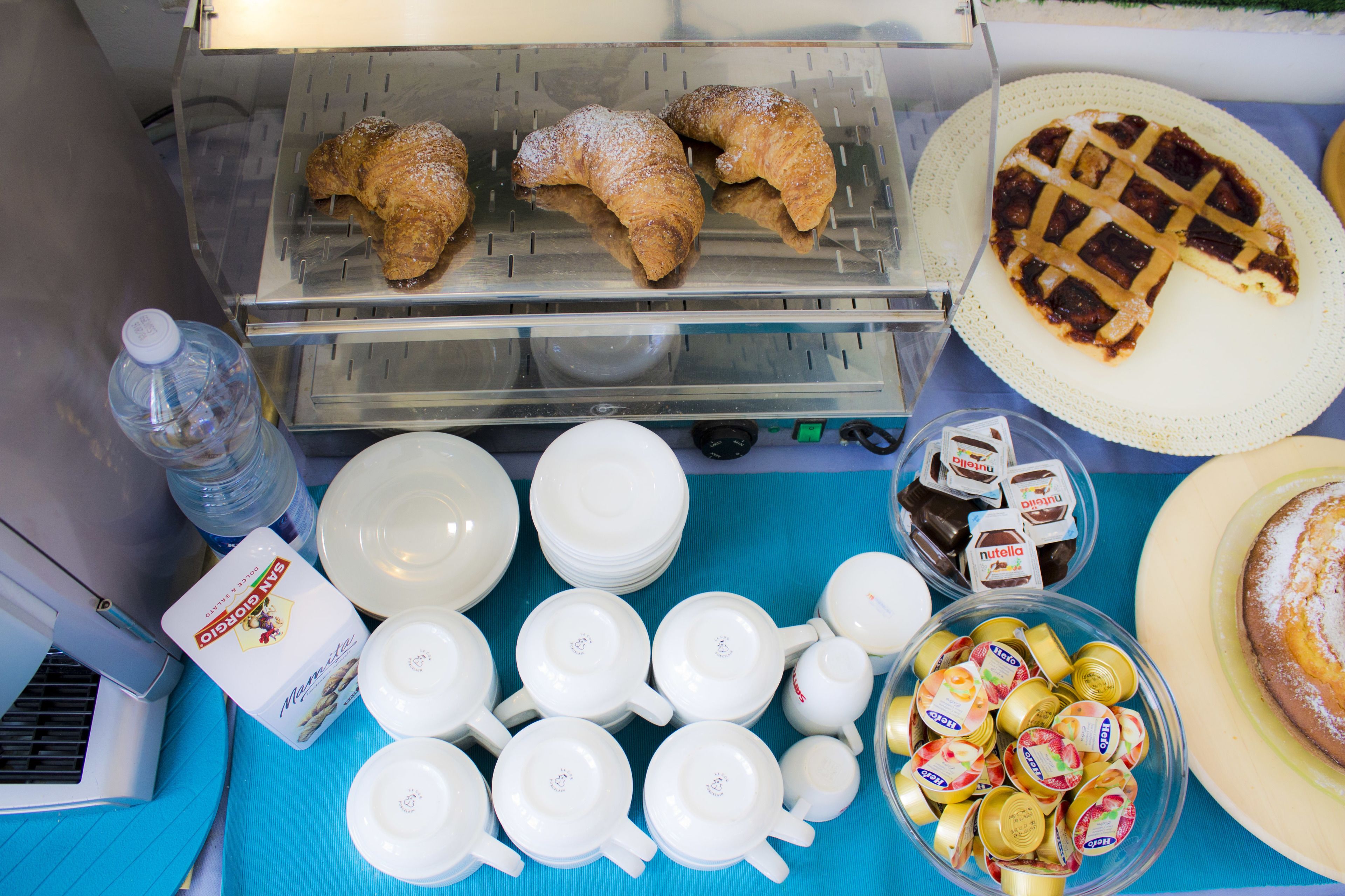 A breakfast buffet with pastries, a pie, and various condiments.