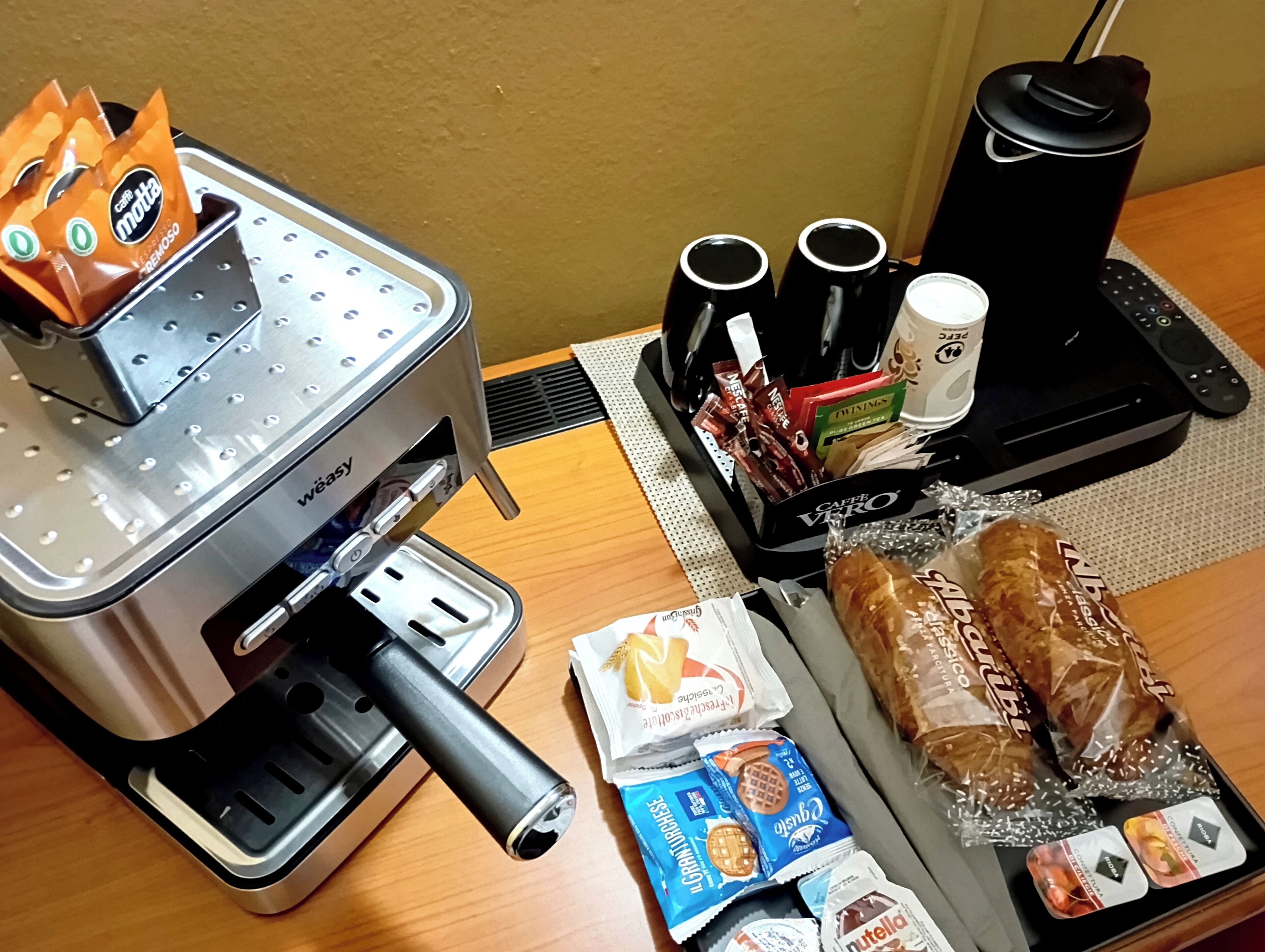 Una kitchenette equipada con cafetera, tostadora, hervidor y máquina de café.