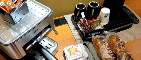 Una kitchenette equipada con cafetera, tostadora, hervidor y máquina de café.
