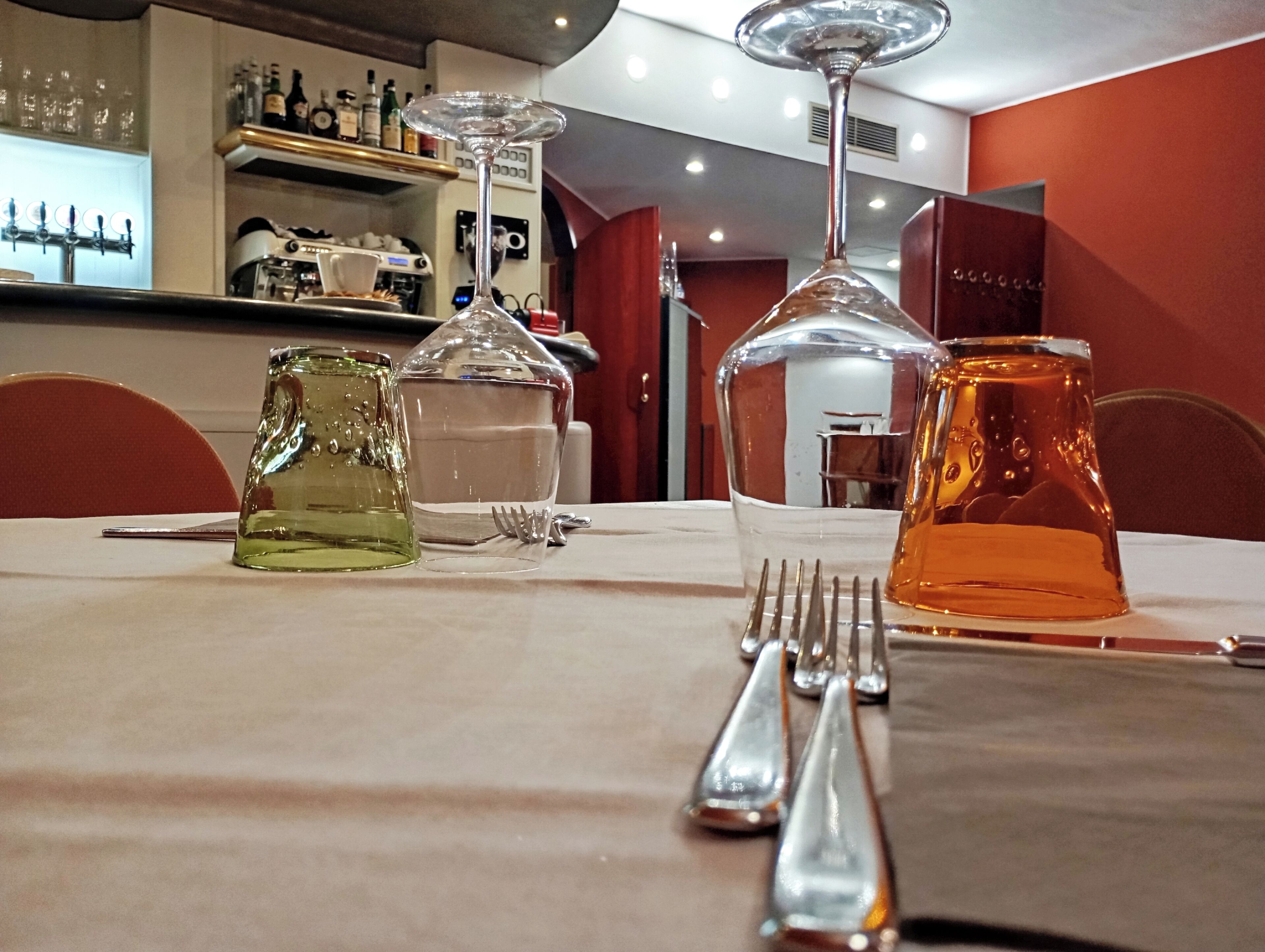 A table set with a clear glass pitcher, a clear glass carafe, and a clear glass decanter, along with a fork and spoon.