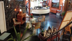A modern hotel lobby with a marble reception desk, a glass coffee table, and a seating area with chairs. - Il Leone D'Oro (Telgate)