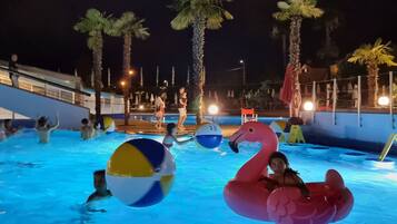 Relax by the pool surrounded by palm trees and enjoy water toys and comfortable seating.