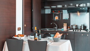 Una cocina moderna con armarios de madera oscura, electrodomésticos de acero inoxidable y un comedor con mantel blanco.