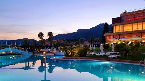 Una piscina con vistas despejadas del paisaje circundante, que incluye palmeras y una montaña al fondo.