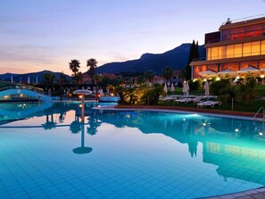 Una piscina con vistas despejadas del paisaje circundante, que incluye palmeras y una montaña al fondo.