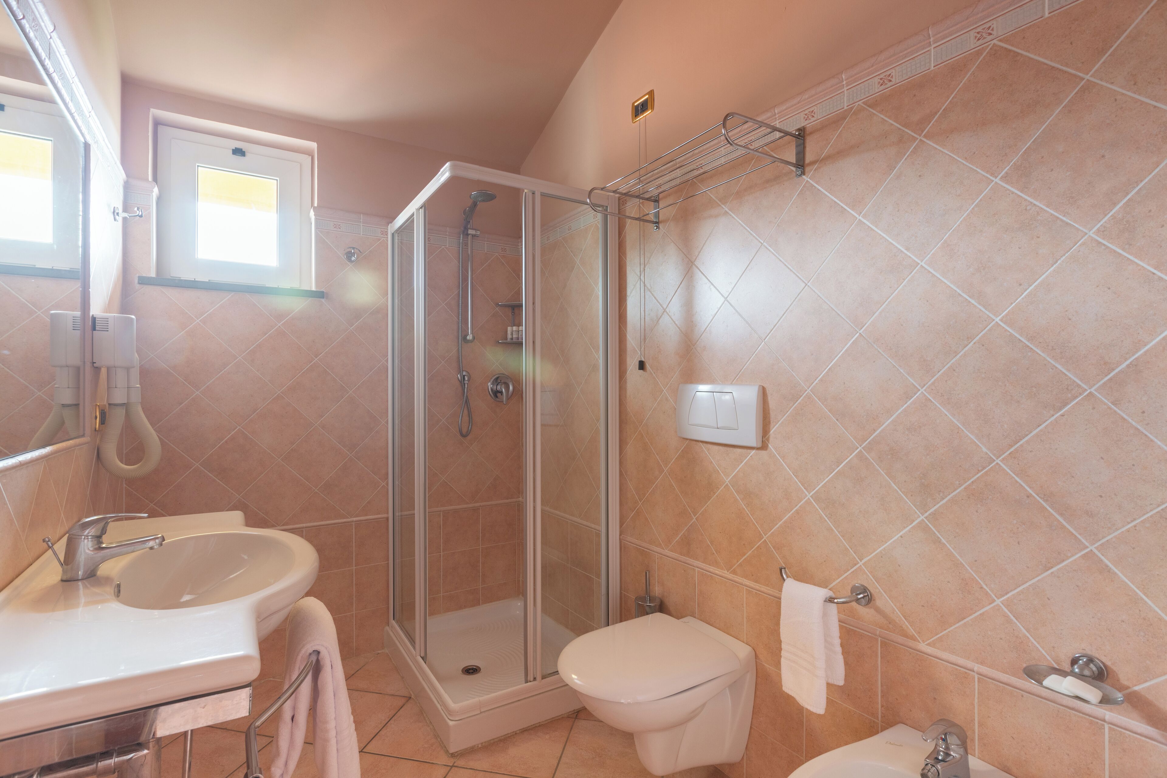 A bathroom with a shower, toilet, and sink.