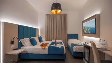 Una habitación de hotel moderna con cama, escritorio, silla, televisor y ventana con cortinas.