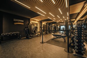 A gym with various exercise equipment, including dumbbells, benches, and weight machines. - Cristallo Levico Terme (Levico Terme)