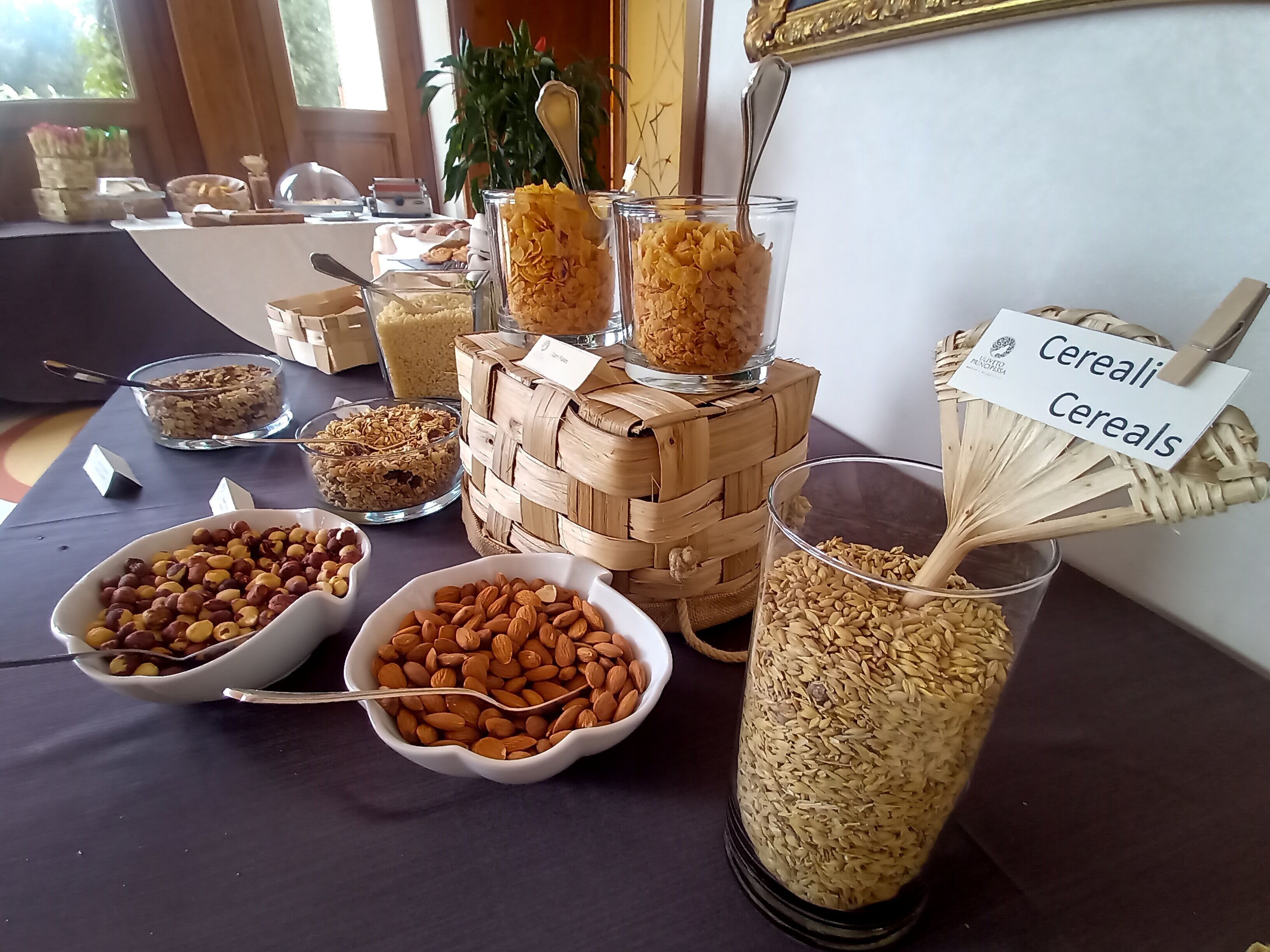 A buffet table with various food items including cereals, nuts, and grains.
