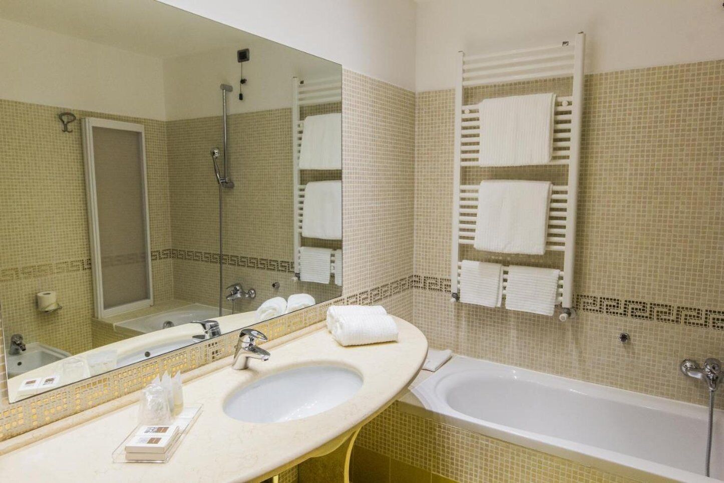 A bathroom with two sinks, a bathtub, and a large mirror.