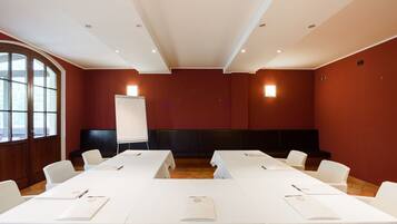 Une salle de conférence avec des tables, des chaises et un tableau blanc, le tout de couleur blanche.