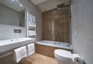 Ein modernes Badezimmer mit einer Badewanne, Toilette und einer Duschkabine.