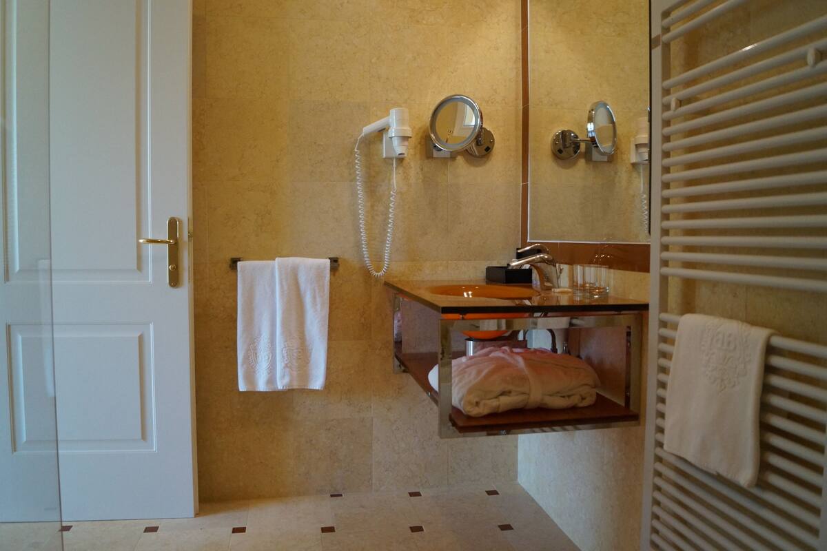 deluxe suite | bathroom | hair dryer, bathrobes, slippers, towels
