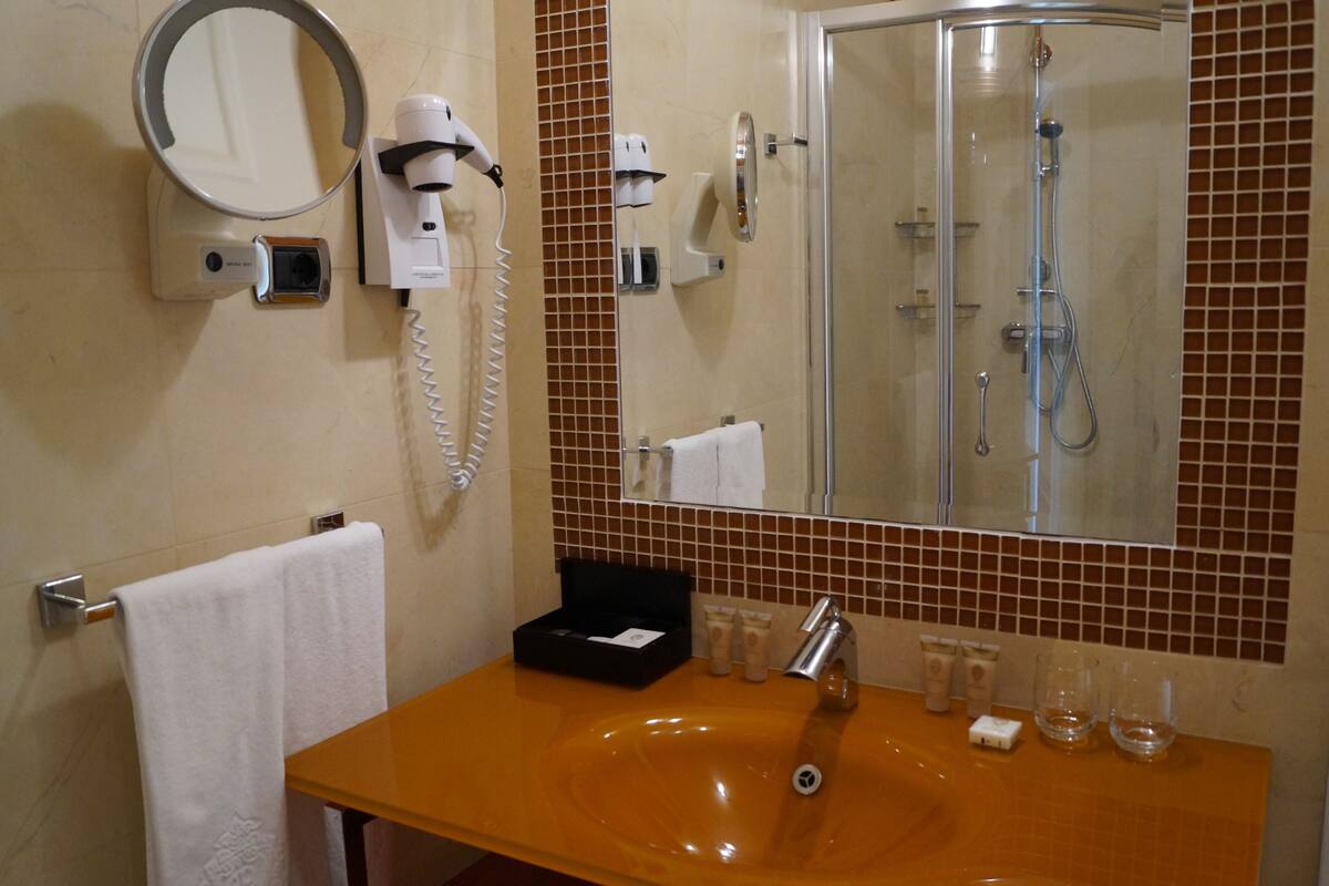 deluxe family suite | bathroom | hair dryer, bathrobes, slippers, towels