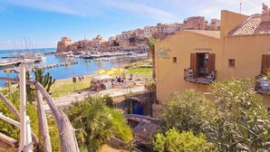 Une ville côtière dotée d’un port de plaisance, d’un hôtel appelé « Cala Marina » et offrant une vue sur la mer.