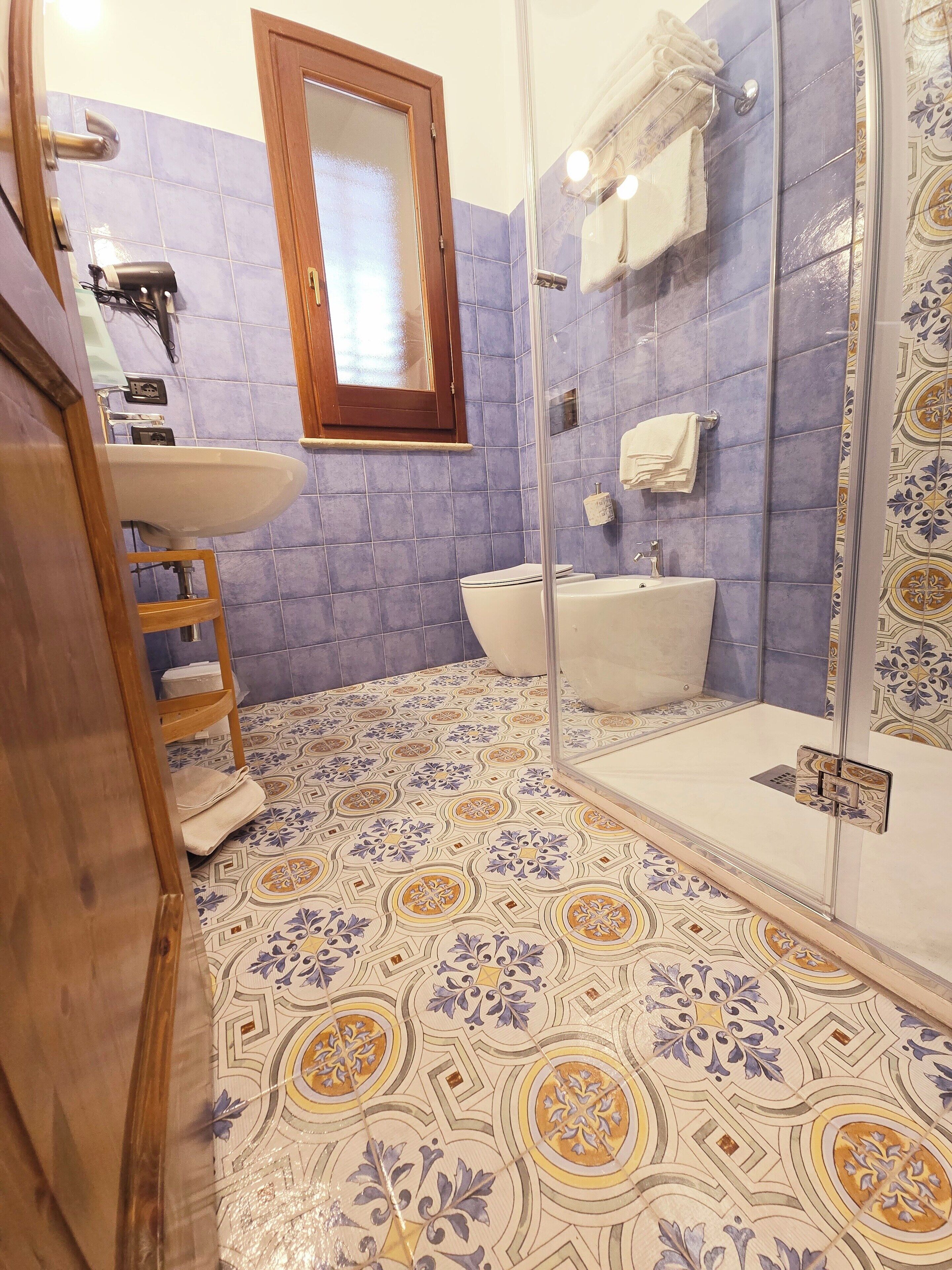 Un baño con ducha, lavabo e inodoro.