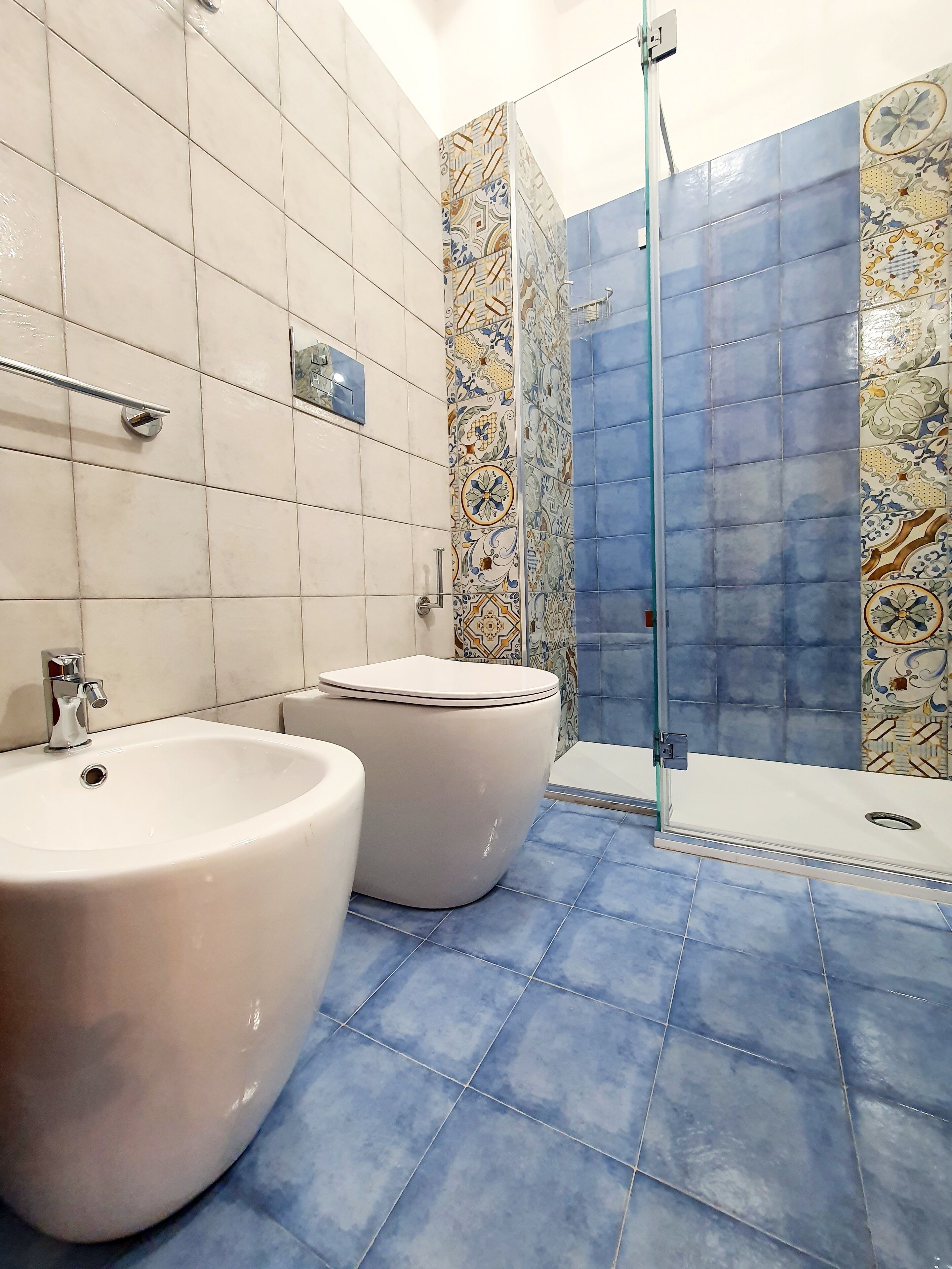 A bathroom with two sinks, a toilet, and a shower area.