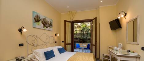 Una habitación de hotel con cama, mesitas de noche, escritorio, silla y televisor.
