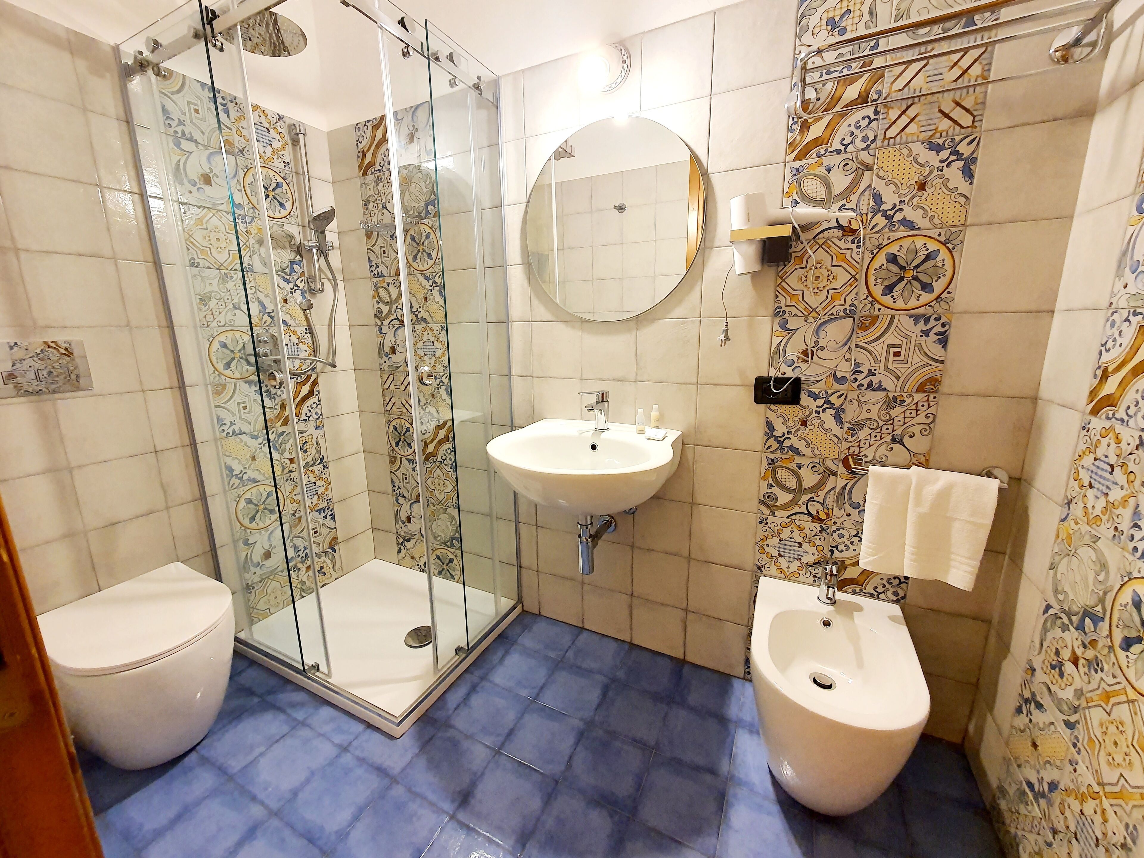 Un baño con ducha, inodoro, bidé y lavamanos.
