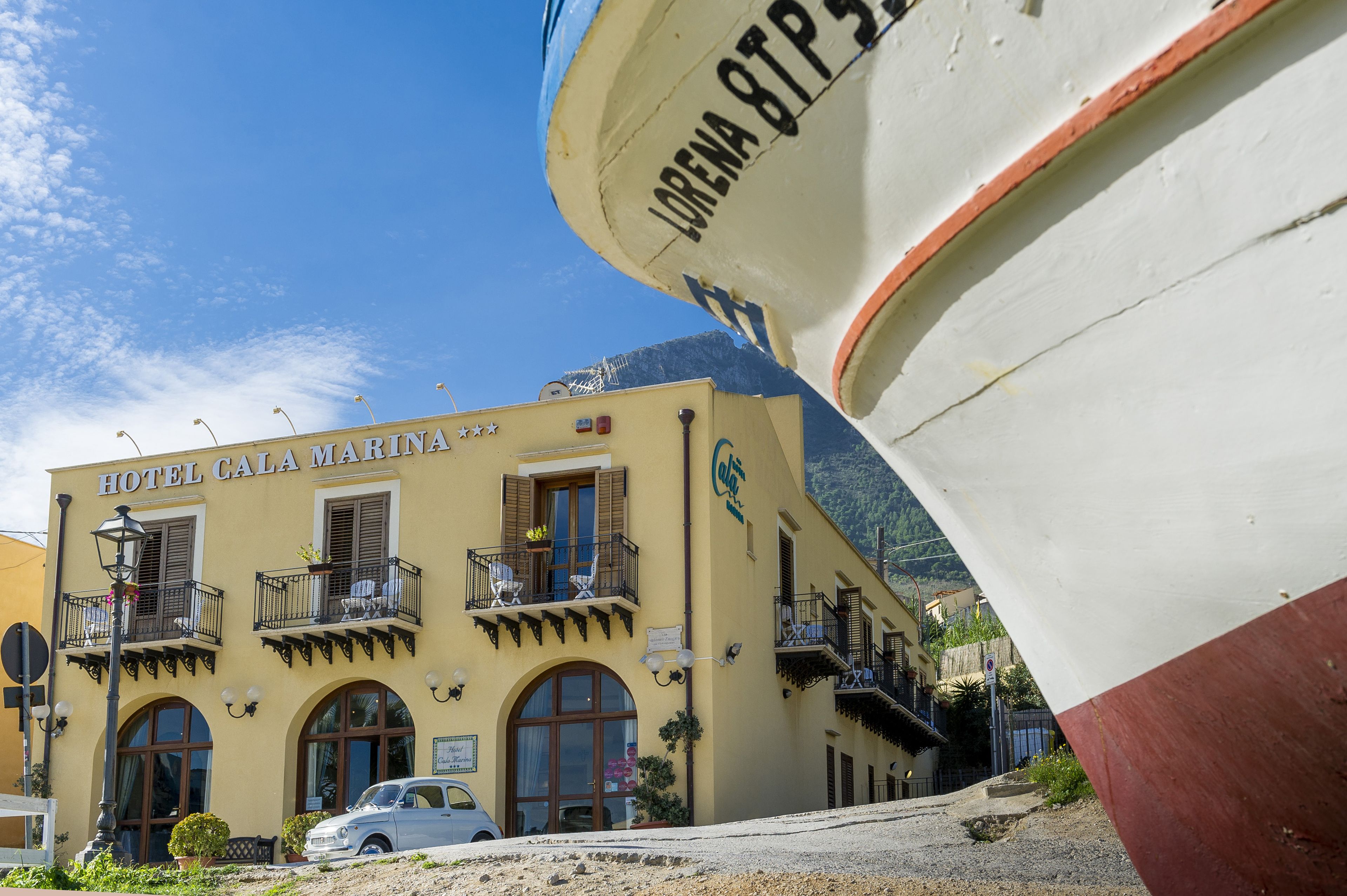 A building with balconies and a sign reading "HOTEL CALA MARINA".