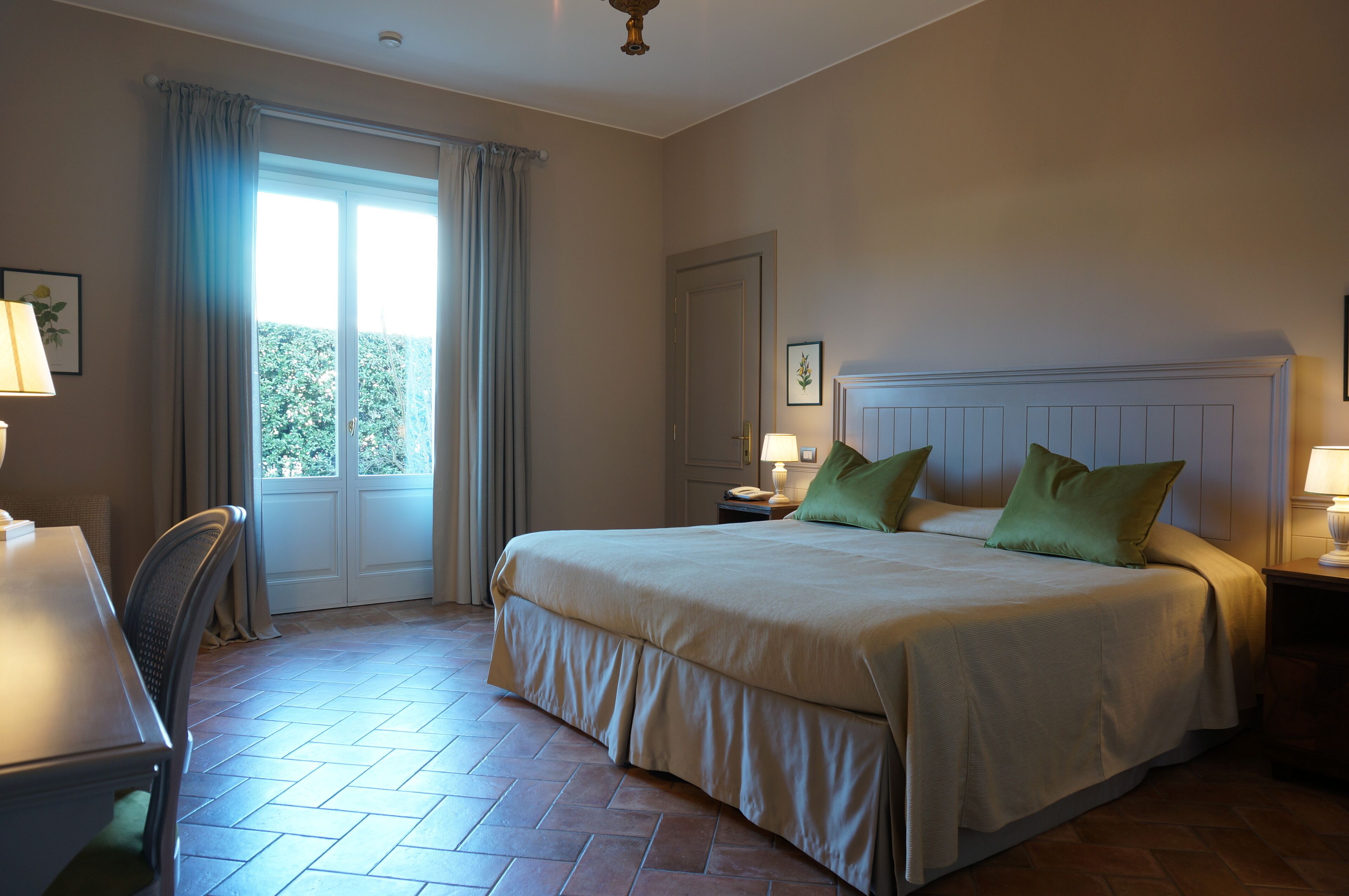 Een hotelkamer met een groot bed, een bureau en een stoel.